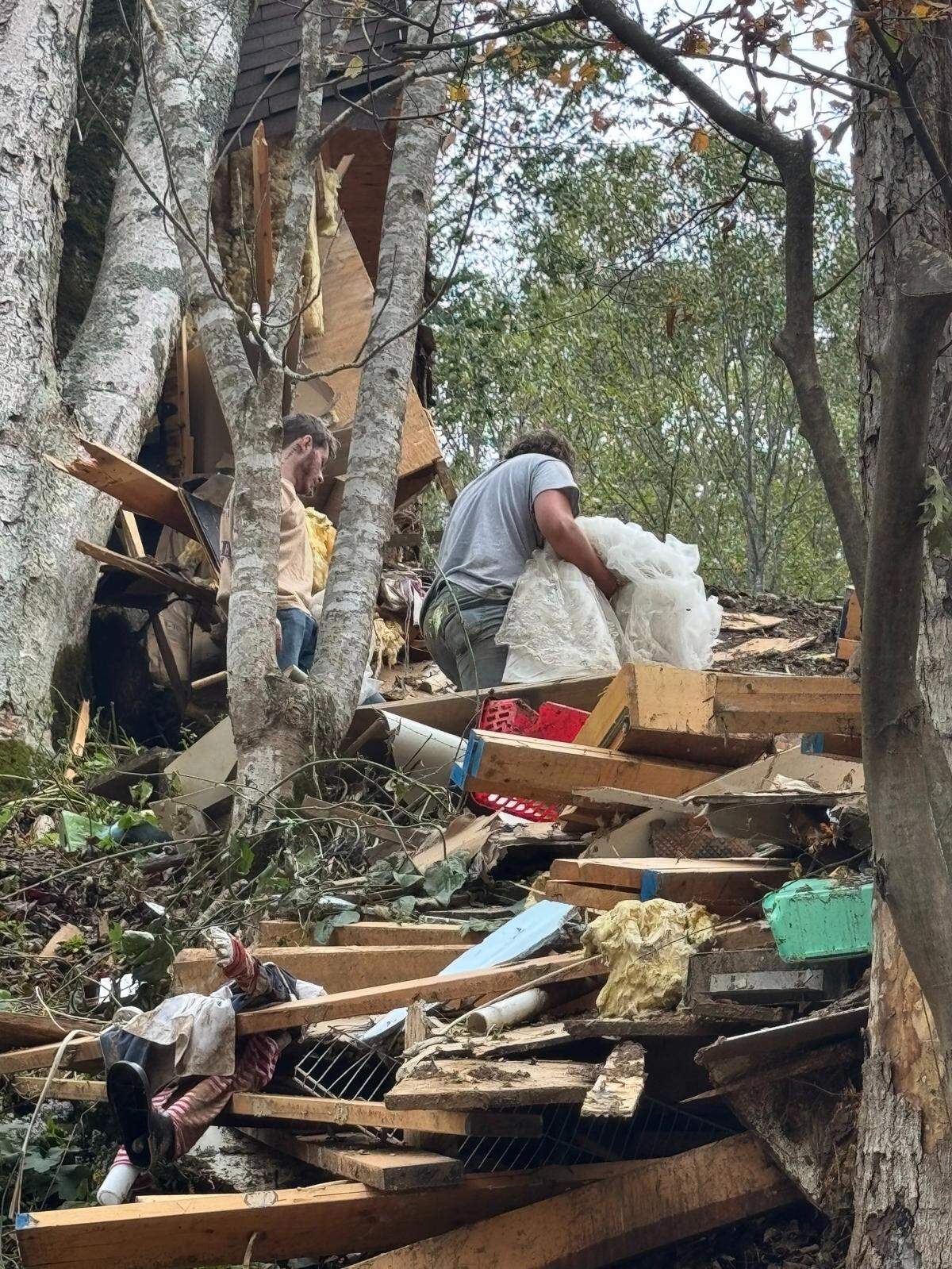 Melissa Guinn’s son Ethan carries her wedding dress out of the wreckage of their home.