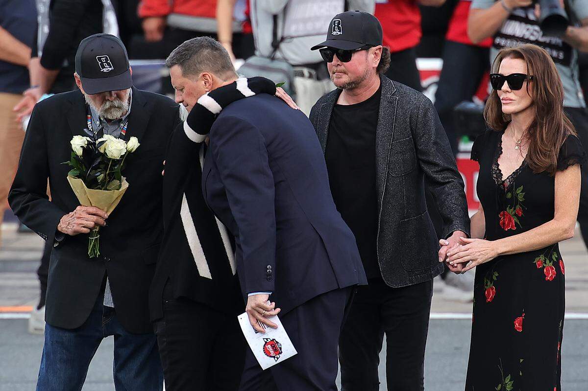 NASCAR Chief Executive Officer Steve O’Donnell embraces Kyle Busch's mother, Gaye Busch, during the remembrance ceremony for Kyle Busch, who passed away suddenly at the age of 41, his father, Tom Busch (L) brother, NASCAR Hall of Famer Kurt Busch and Lyda Moore on the grid prior to the NASCAR Cup Series Coca-Cola 600 at Charlotte Motor Speedway on May 24, 2026 in Concord.