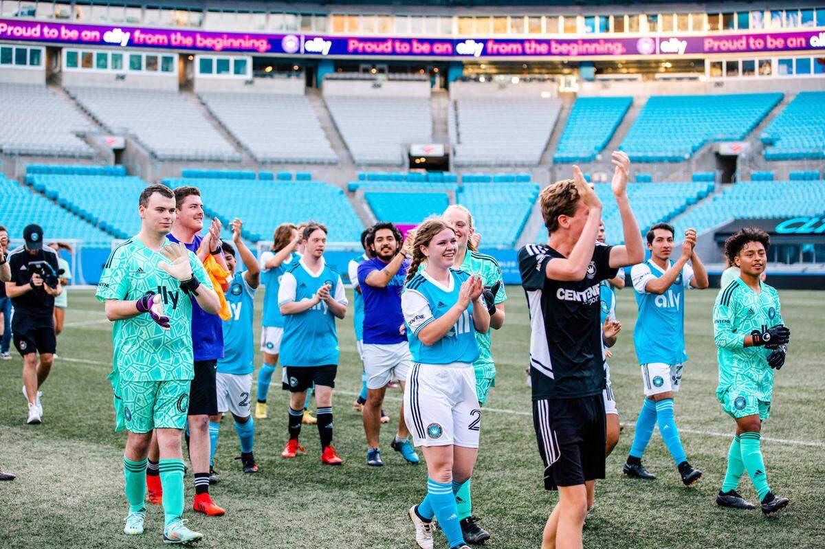 Emily Burkholder claps toward the sideline with her teammates after the Unified Team’s scrimmage on Signing Day on April 18, 2023, at Bank of America Stadium.