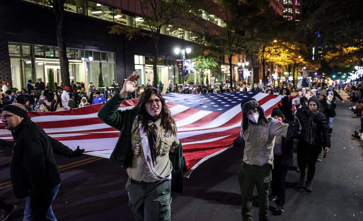 Boy Scouts carry an American flag at the 2021 Novant Health Thanksgiving Parade.