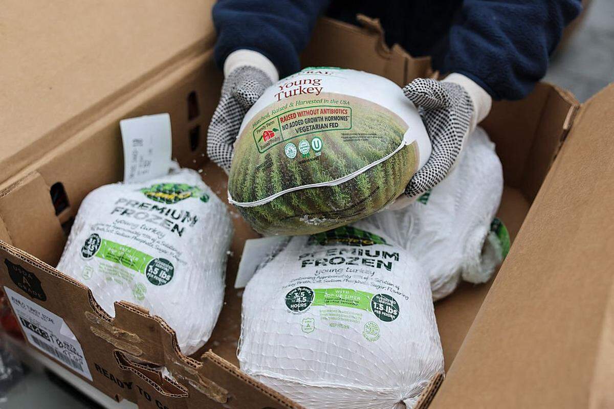 A person holds a frozen turkey during a Thanksgiving food distribution event outside of Brooklyn Borough Hall on November 21, 2025 in New York City. Fresh produce, non-perishables and other food items were handed out to 125 Brooklyn houses of worship, community kitchens and other community-based organizations addressing food insecurity and homelessness. (Photo by ANGELA WEISS / AFP via Getty Images)