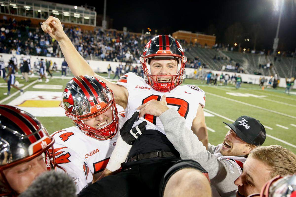 Lucas Carneiro of the Western Kentucky Hilltoppers is hoisted after scoring the winning field goal against the Old Dominion Monarchs in overtime during the Famous Toastery Bowl at Jerry Richardson Stadium on Dec. 18, 2023, in Charlotte.
