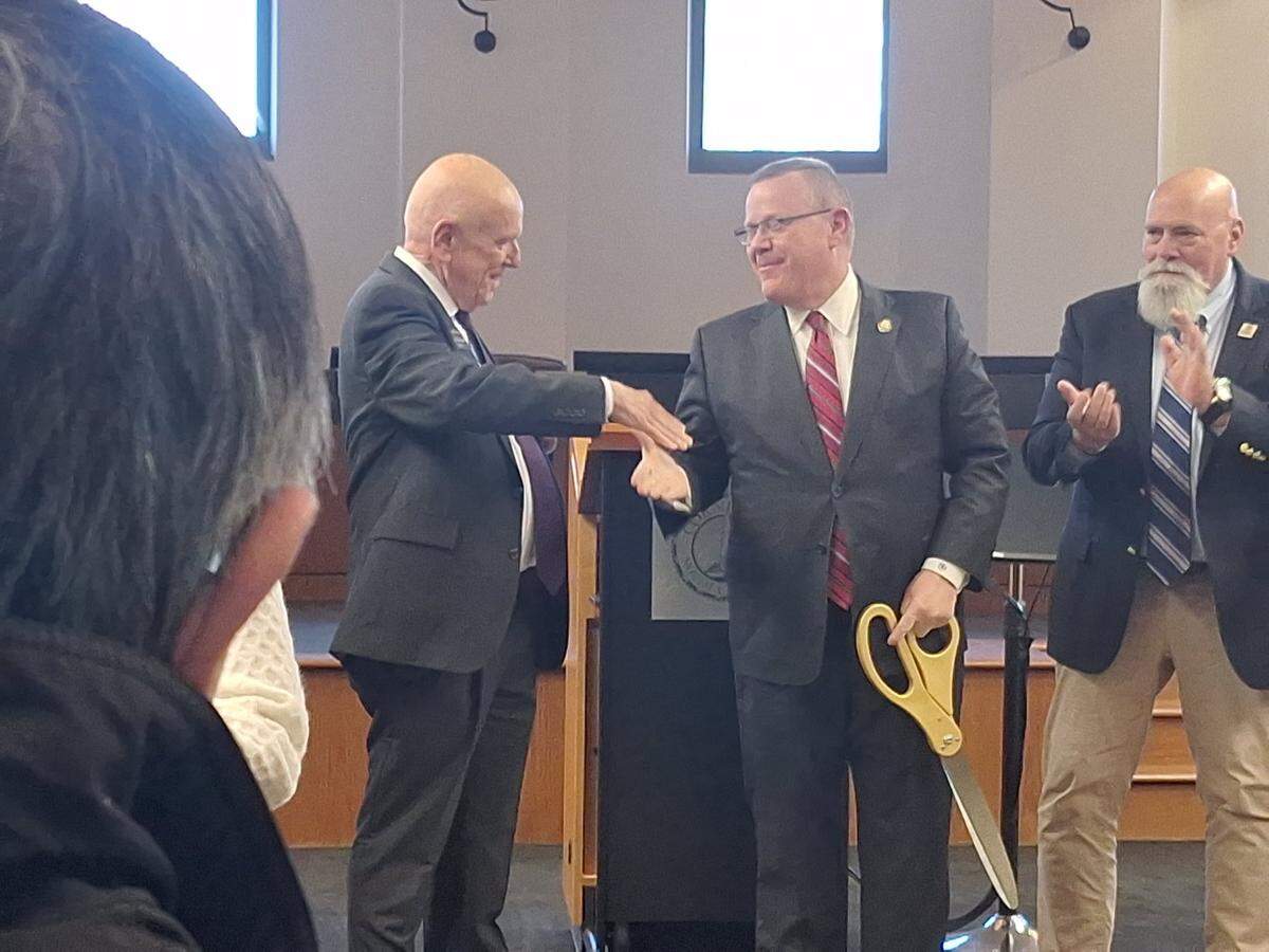 U.S. Rep. Tim Moore opened a congressional office in Cornelius Town Hall on Thursday, Feb. 20, 2025. Mayor Woody Washam, at left, shakes hands with Moore after Moore cut the ceremonial ribbon for the office.