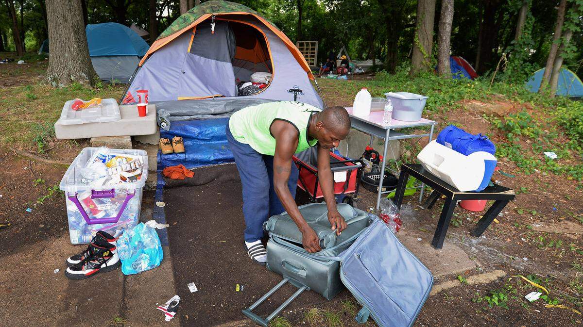 Anthony Martin tends to items in his encampment in a lot along Poplar and 12th Streets in Charlotte. In August, Martin and other homeless people living on the lot received a notice informing them that they were trespassing on private property and telling them to vacate.