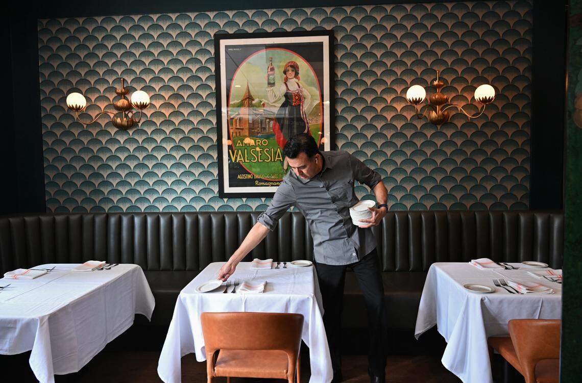 A server preps the tables for service at Aqua e Vino.