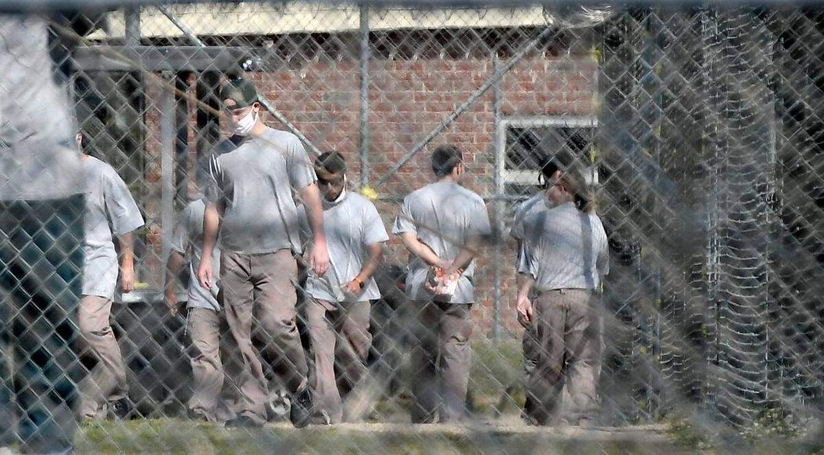 Inmates at Neuse Correctional Institution, in Goldsboro, move between buildings Sunday.