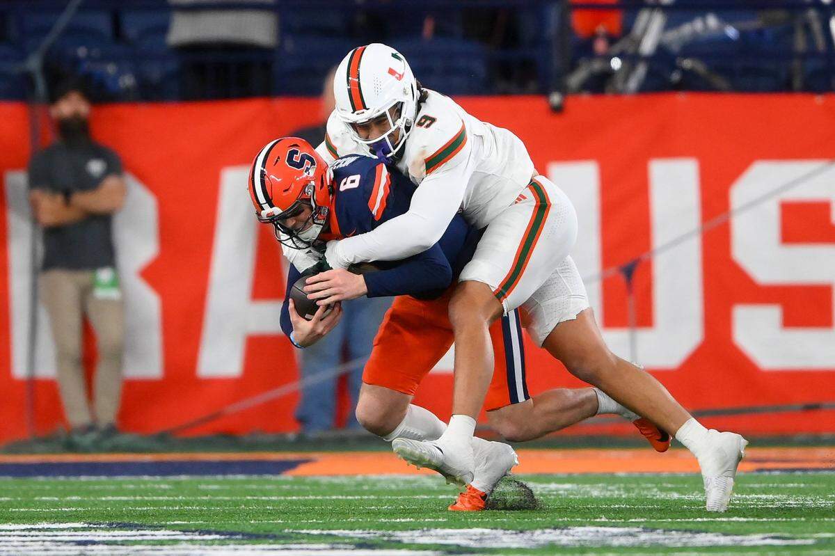 Nov 30, 2024; Syracuse, New York, USA; Miami Hurricanes defensive lineman Tyler Baron (9) sacks Syracuse Orange quarterback Kyle McCord (6) during the second half at the JMA Wireless Dome. Mandatory Credit: Rich Barnes-Imagn Images