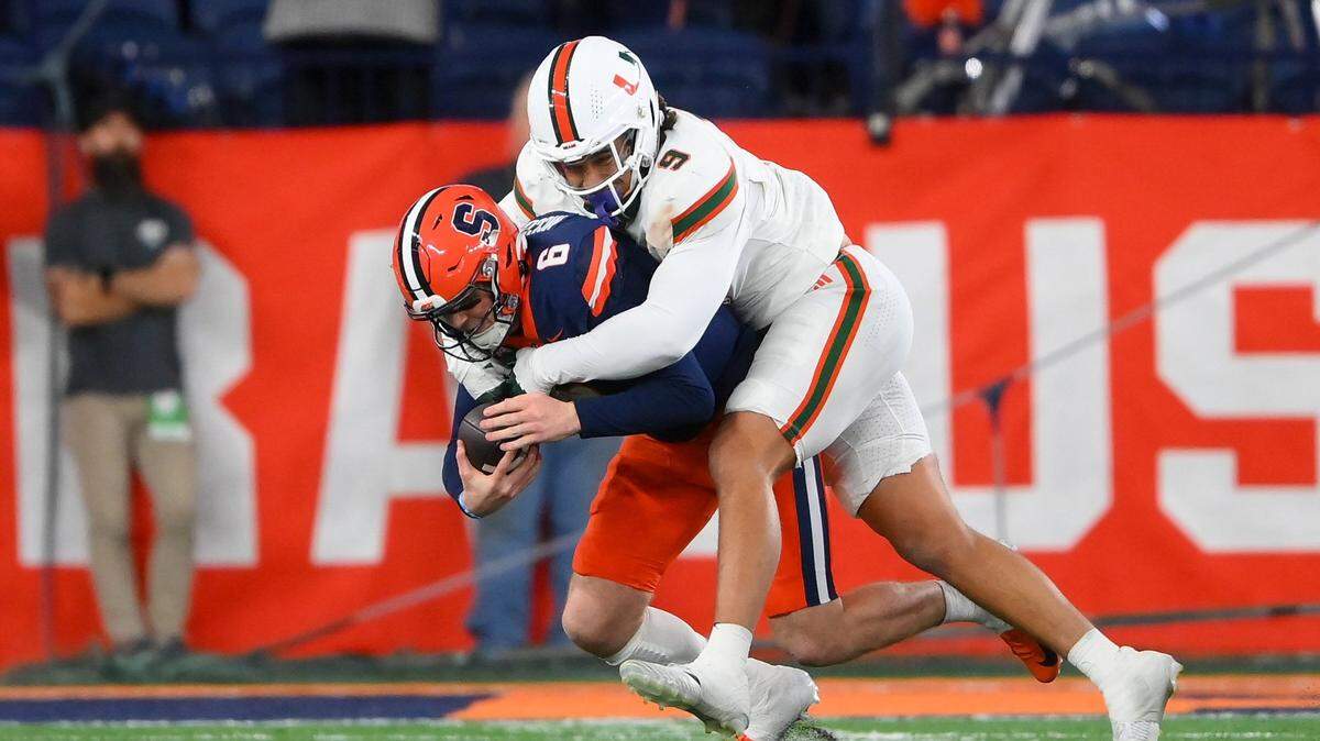 Nov 30, 2024; Syracuse, New York, USA; Miami Hurricanes defensive lineman Tyler Baron (9) sacks Syracuse Orange quarterback Kyle McCord (6) during the second half at the JMA Wireless Dome. Mandatory Credit: Rich Barnes-Imagn Images