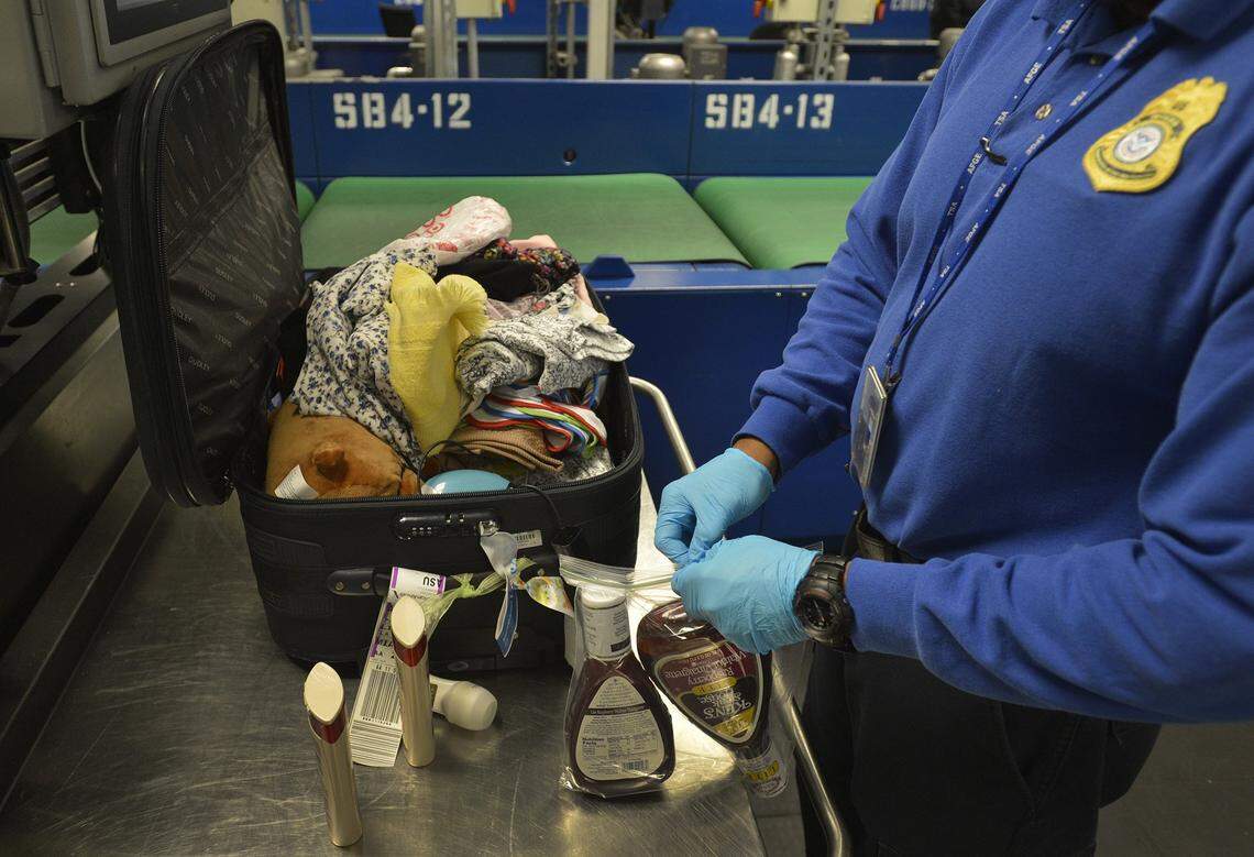 A TSA agent examines baggage at Charlotte Douglas International Airport. Employees are facing a partial government shutdown, which is causing delays at major U.S. airports. 