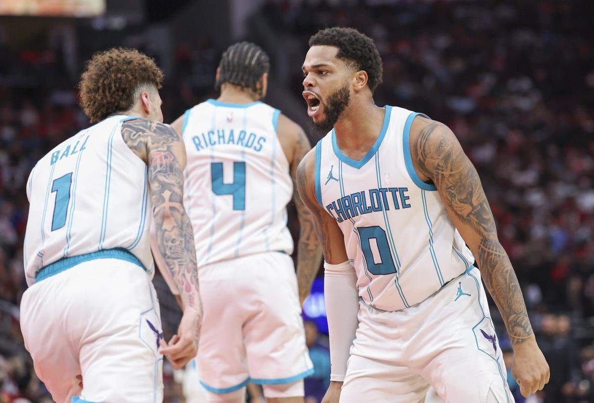 Charlotte Hornets forward Miles Bridges (0) celebrates with guard LaMelo Ball (1) after scoring a basket during the fourth quarter against the Houston Rockets at Toyota Center.