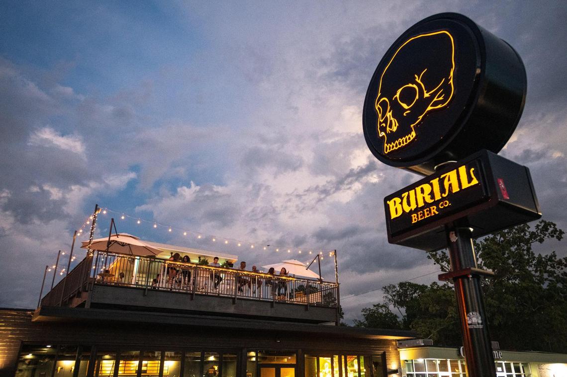 Patrons enjoy drinks on the rooftop bar at Burial Beer Co. in Plaza Midwood. The brewery opened in June 2022.