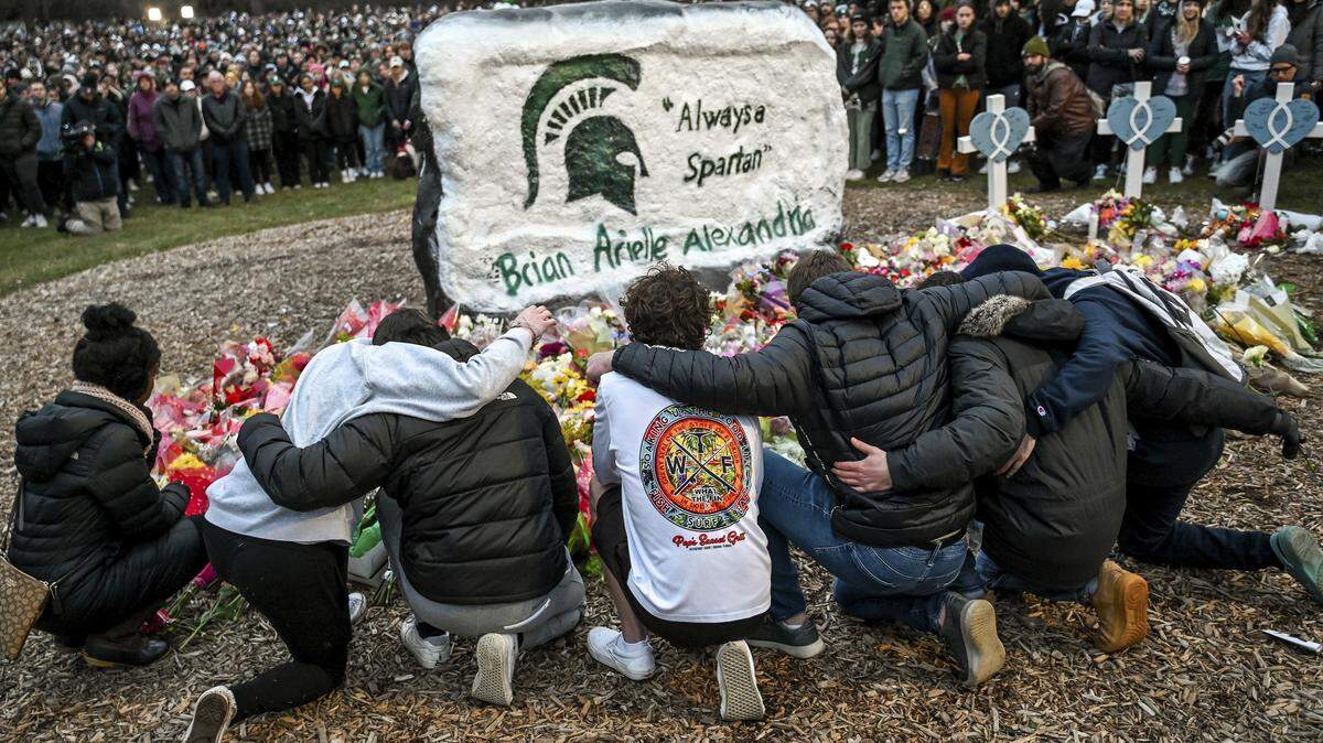 Friends of Brian Fraser gather around The Rock on the campus of Michigan State University, in East Lansing, Mich., on Wednesday, Feb. 15, 2023, during a vigil honoring MSU shooting victims Fraser, Arielle Anderson, Alexandria Verner and the five others injured.