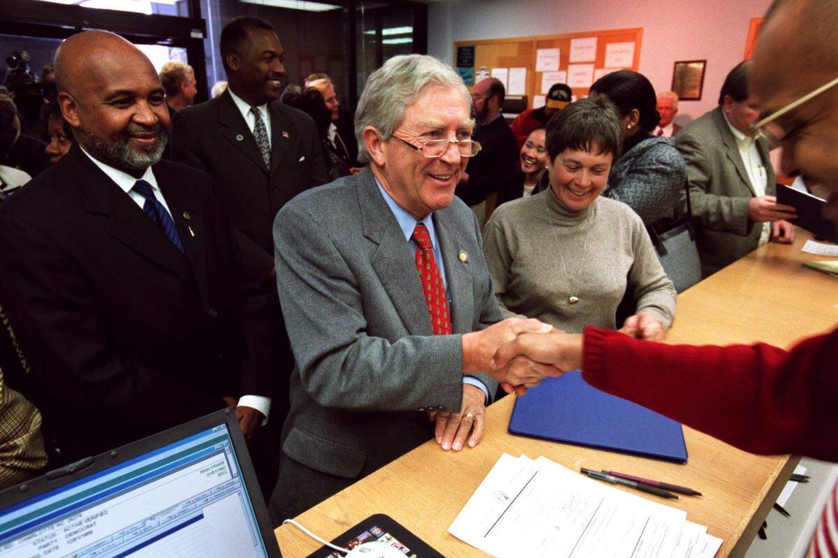 State Sen. Fountain Odom, middle, shakes Tony Jordan’s hand after filing with the Mecklenburg County Board of Elections. File photo.