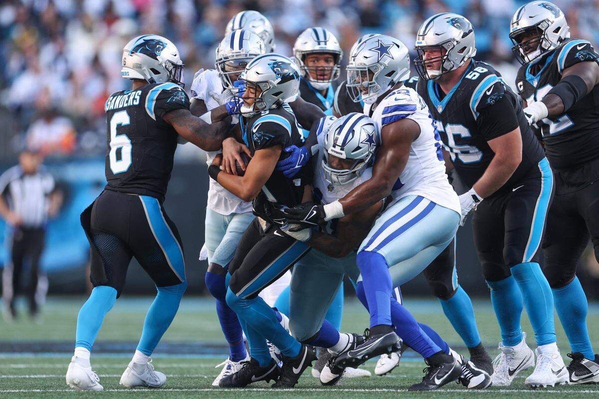 Panthers running back Miles Sanders (6) tries to assist as quarterback Bryce Young (9) get sacked by Cowboys defensive tackle Osa Odighizuwa (97) during the game at Bank of America Stadium on Sunday, November 19, 2023 in Charlote, NC.