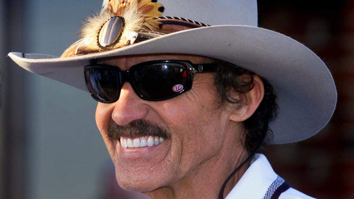 In this Oct. 6, 1999, file photo, seven-time Winston Cup champion Richard Petty, of Level Cross, N.C., smiles as he talks in the garage area at the Lowe's Motor Speedway in Concord, N.C. Petty says after “accumulating stuff” for 80 years, it’s time to sell some of his most famous cars, trophies and other items. Petty's iconic day-glow red and Petty blue 1974 Dodge Charger is going on sale at an auction on Saturday at Planet Hollywood in Las Vegas, along with other cars, his 1981 Daytona 500 trophy and other items.