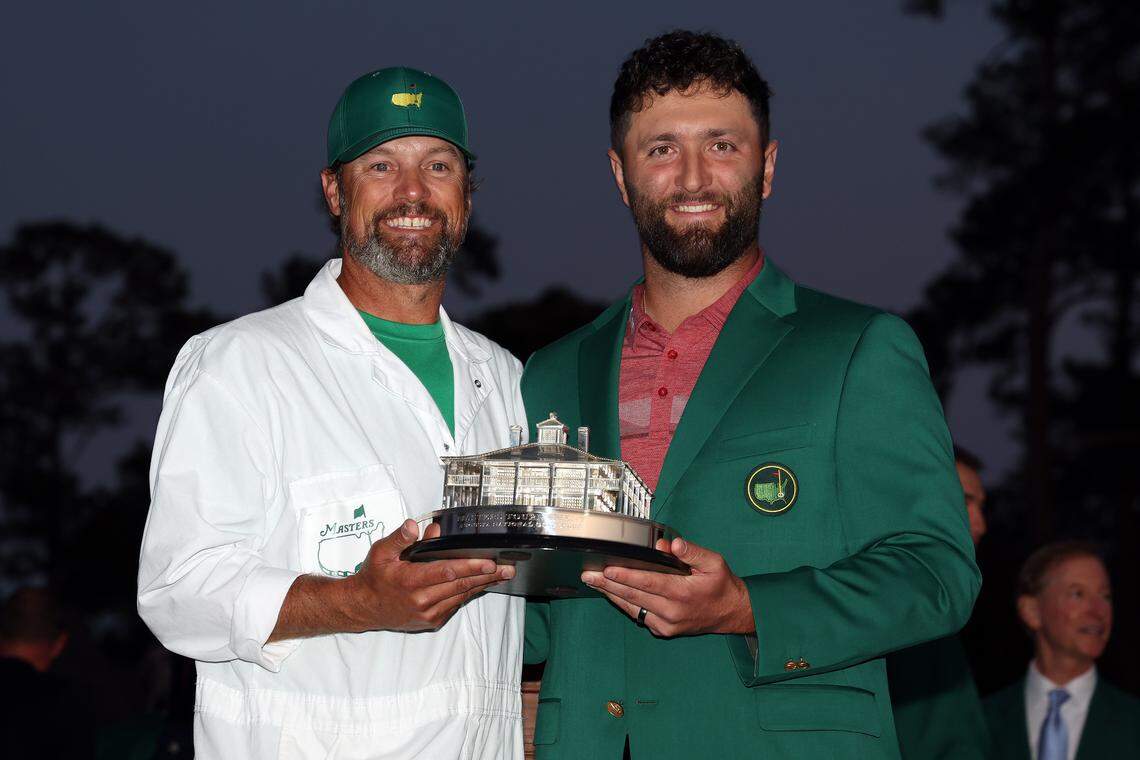 Jon Rahm of Spain poses with the Masters trophy and his caddie Adam Hayes during the Green Jacket Ceremony after winning the 2023 Masters Tournament at Augusta National Golf Club on April 9, 2023, in Augusta, Georgia.