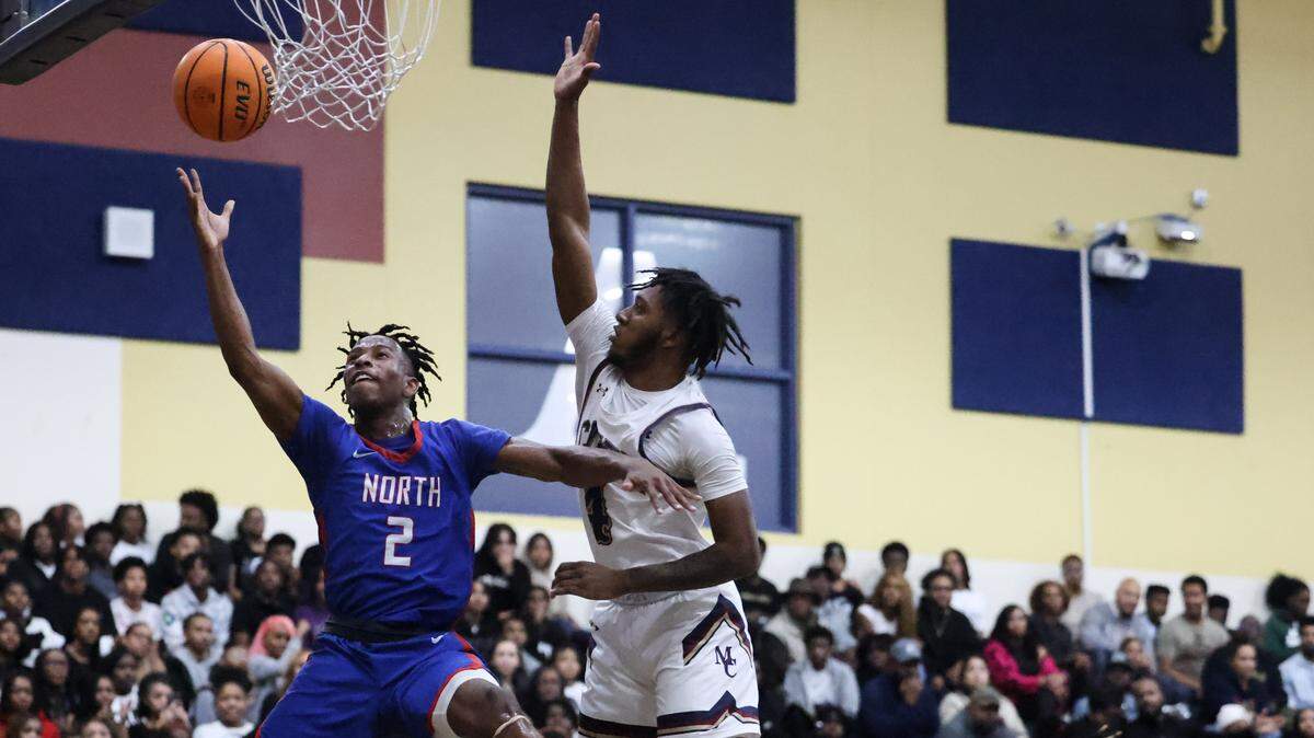 North Mecklenburg’s Carson Evans, left, shoots past a block by Mallard Creek’s Kanya Caddle at Mallard Creek High School in Charlotte, N.C., on Friday, December 15, 2023.