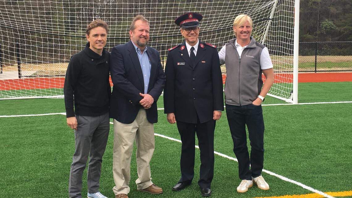 Dustin Swinehart (far right) and Jorge Herrera (far left) of the Charlotte MLS Community Engagement team pose with leaders of the Salvation Army at the unveiling of Kevin Harvick Field at Group1001 Park in East Charlotte.