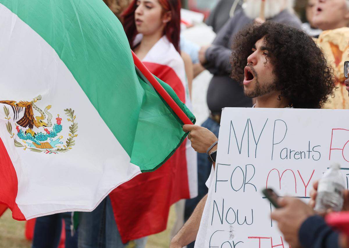 Marlon Florian holds a Mexican flag during the No Border Patrol protest in uptown Charlotte on Saturday, Nov. 15, 2025.
