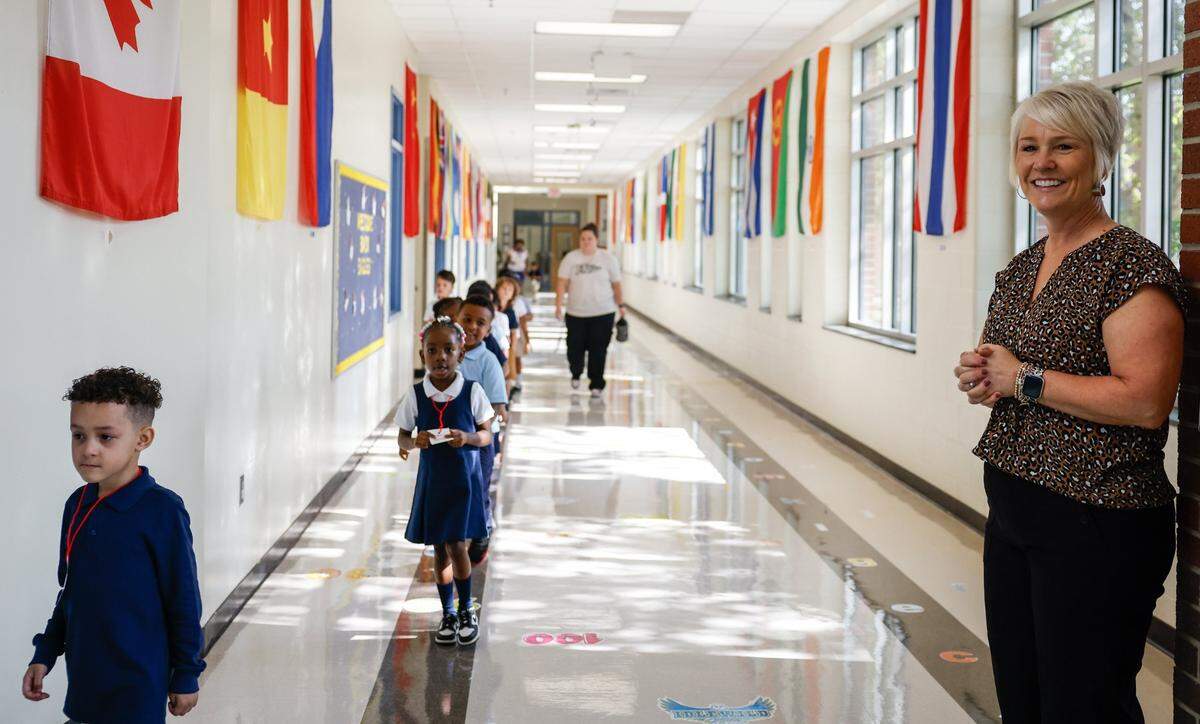 Idlewild Elementary School Principal Trish Stewart smiles at studetns as they walk down the hall during the first day of school on Monday, August 26, 2024.