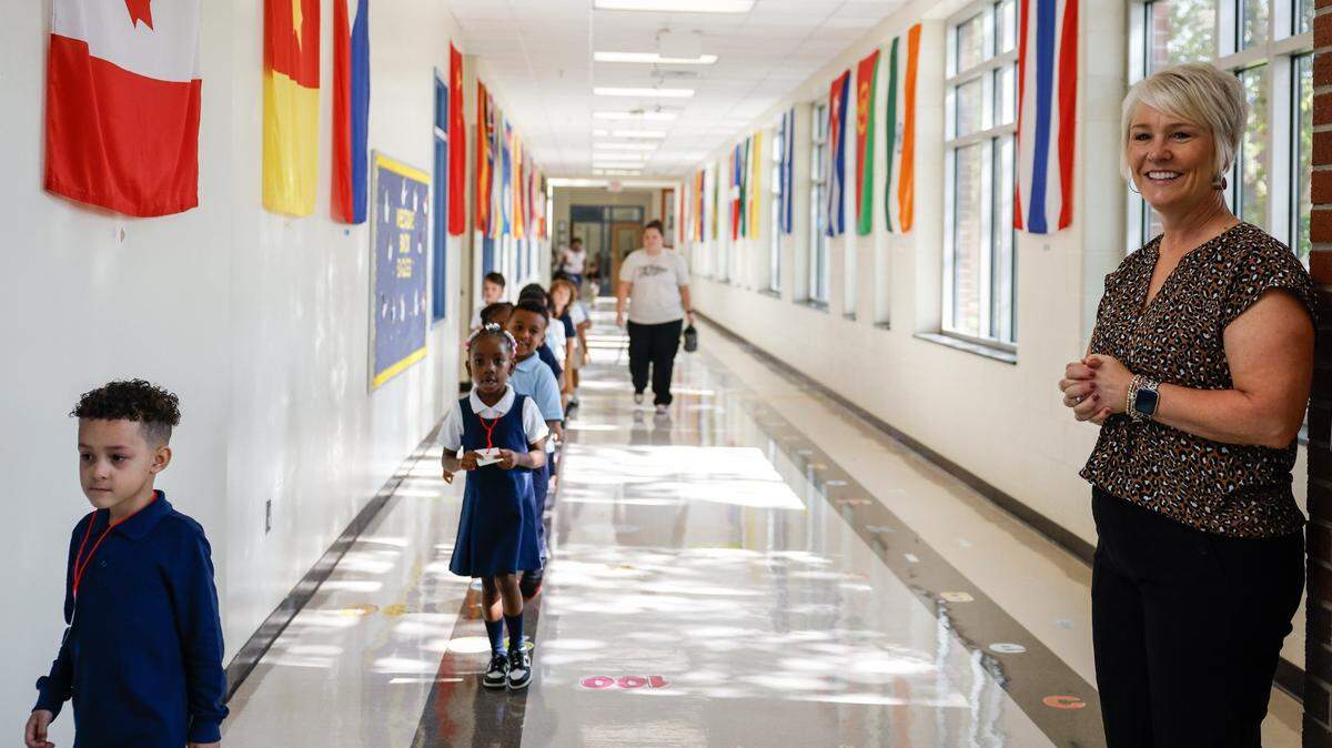 Idlewild Elementary School Principal Trish Stewart smiles at students as they walk down the hall during the first day of school on Monday, August 26, 2024.