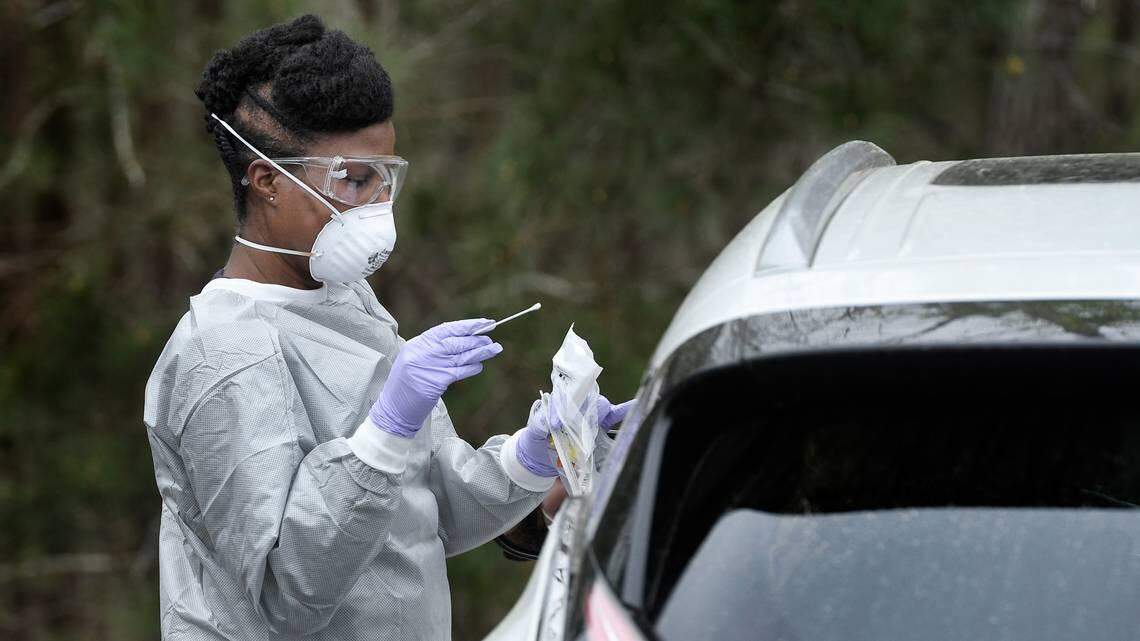Family nurse practitioner Schquthia Peacock prepares to do a nasal swab in June 2020 to test a patient for coronavirus in the parking lot at Preston Medical Associates in Cary.