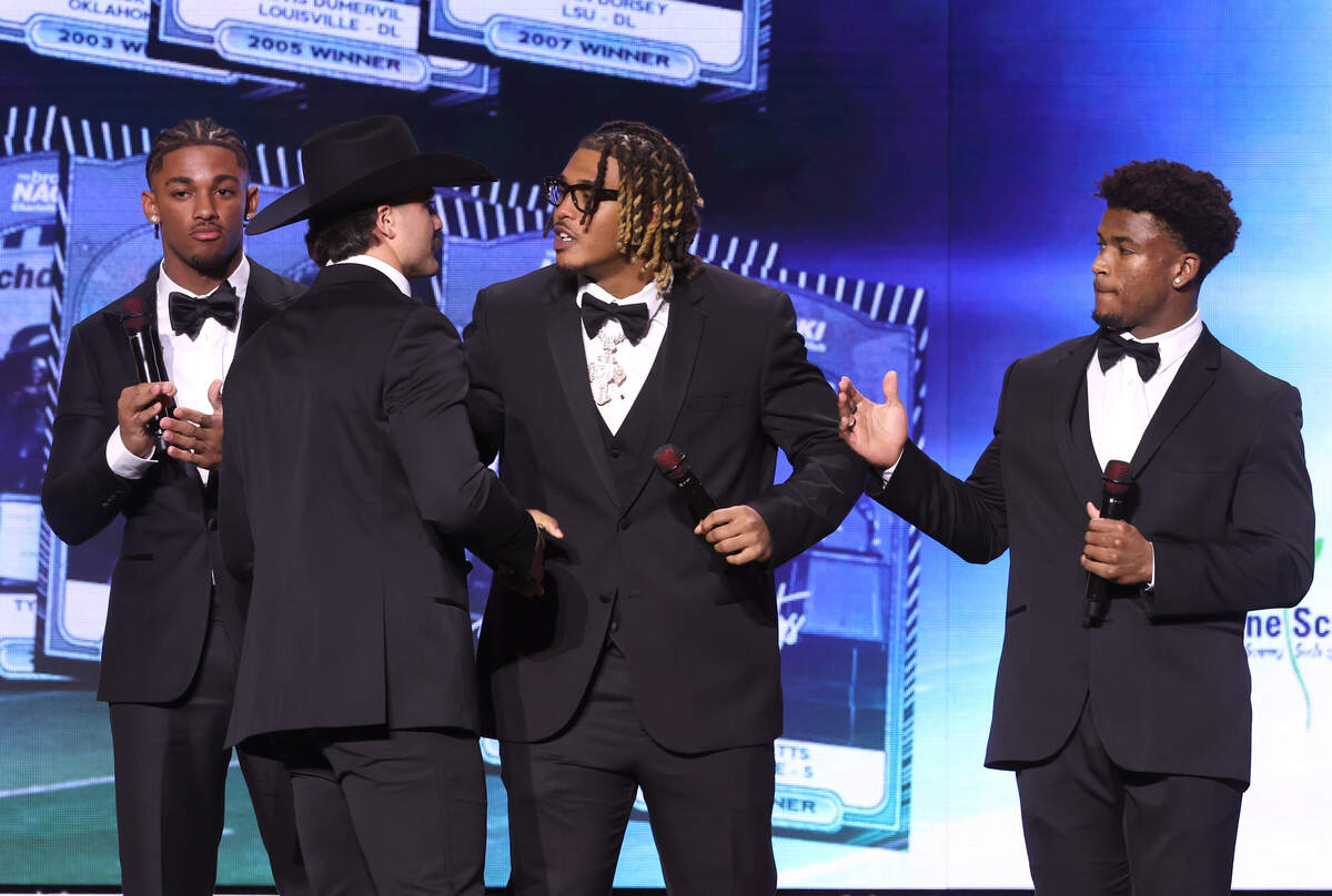 Texas Tech linebacker Jacob Rodriguez, second from left, is congratulated by fellow 2025 Bronko Nagurski Trophy nominees (L-R) Leonard Moore, cornerback Notre Dame, Cashius Howell, defensive end Texas A&M and Caleb Downs, safety Ohio State, after Rodriguez won the award  in Charlotte, NC on Monday, December 8, 2025. The program was hosted by the Charlotte Touchdown Club. The award is presented to the NCAA D1 National Defensive Player of the Year.