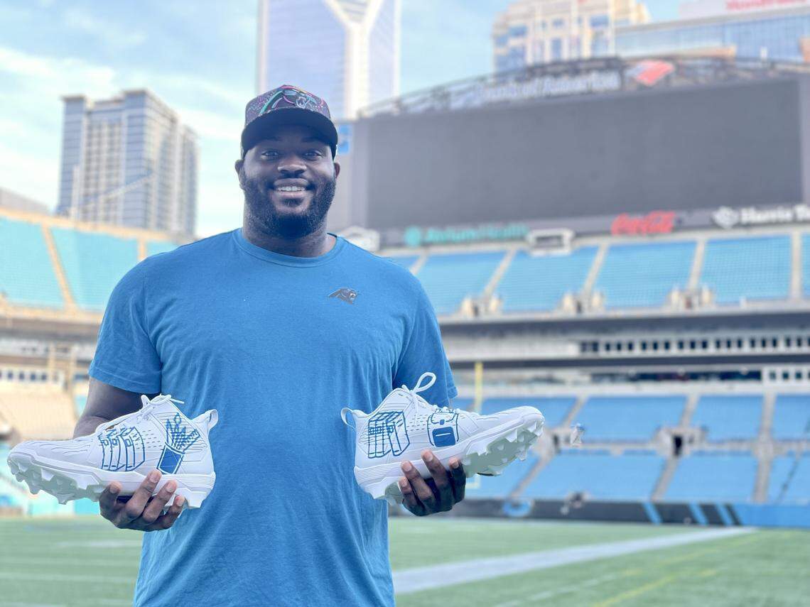 Carolina Panthers offensive lineman Taylor Moton poses with his freshly painted and designed cleats in Bank of America Stadium ahead of his “My Cause, My Cleats” game. His cleats are focused on helping public education.