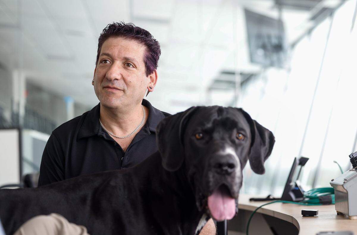 Dan Lovenheim and his dog, a 2½-year-old black Great Dane named Cub, sit above the Rockingham Speedway on Monday, March 31, 2025. Lovenheim started with a $3.5 million repave of what he calls “Big Rock,” the famed mile oval. (The facility also is home to a short track — “Little Rock” — and an infield road course.) After that, there were HVAC systems to install, bathrooms to clean and refurbish, pit garages to renovate. By May 2023, it was “90% ready” to host a daytime NASCAR race. By August, once the announcement came, it was closer — save for a few more NASCAR safety specifications required of all facilities, including SAFER barriers on all walls of the track. All in all, with the money put forth by Lovenheim himself and the government, about $15 million has gone into Rockingham’s revival, Lovenheim said.