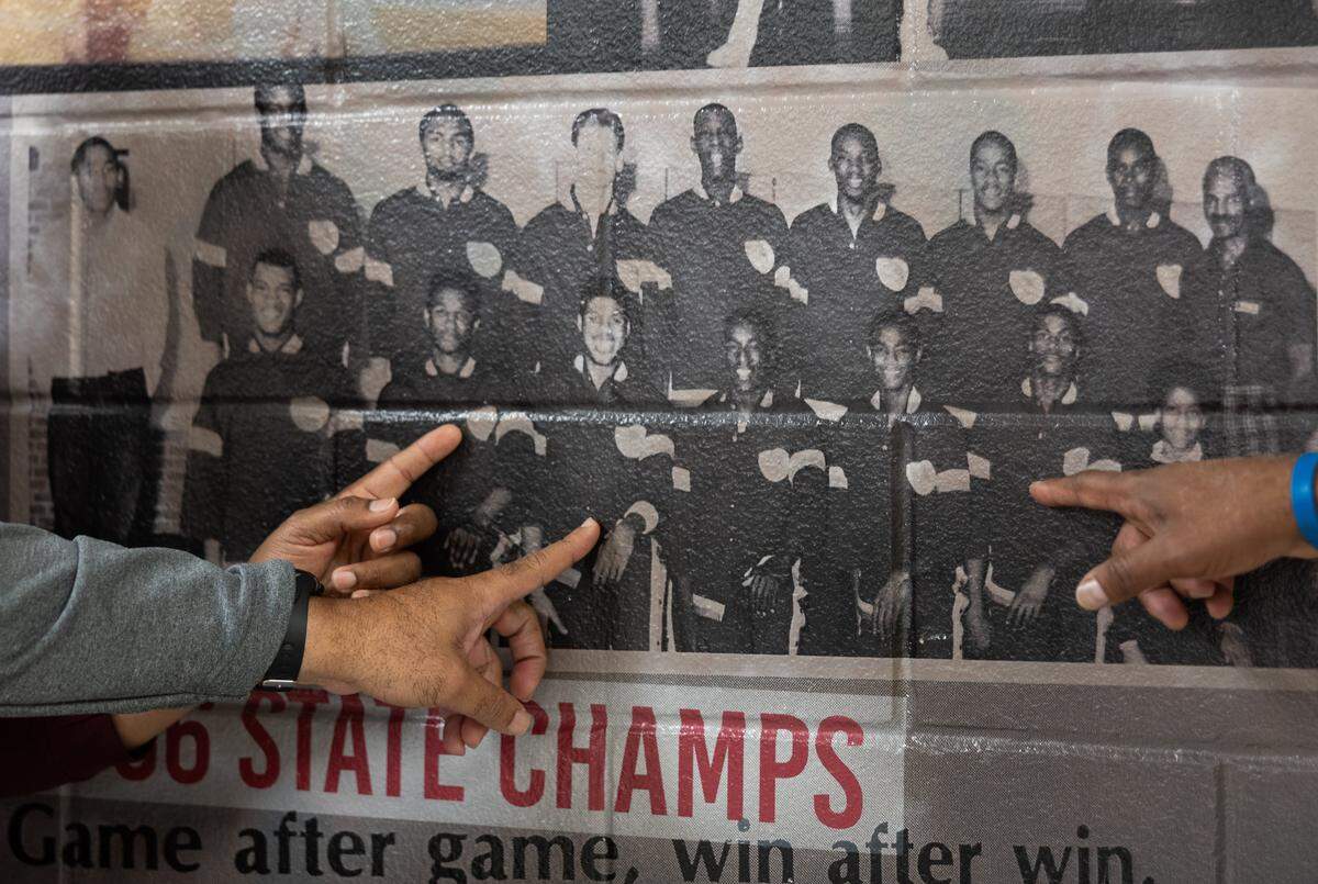 West Charlotte 1986 State Championship basketball players, Maurice Caldwell, Duane Montgomery and Jules Springs point to themselves in a group photo at West Charlotte High School in Charlotte, N.C., on Monday, March 9, 2026. 