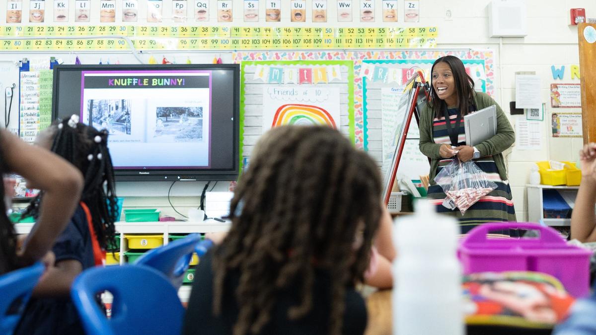 Principal Danielle Belton greets students and hands out Smarties candy at Paw Creek Elementary in Charlotte, N.C., on Wednesday. The school is one of the most improved in the state for the second year in a row.