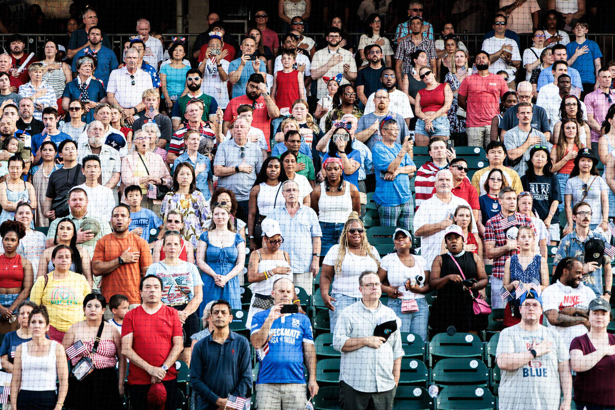 People stand for the national anthem at Truist Field during the annual Stars and Stripes Spectacular on Saturday July 4, 2026