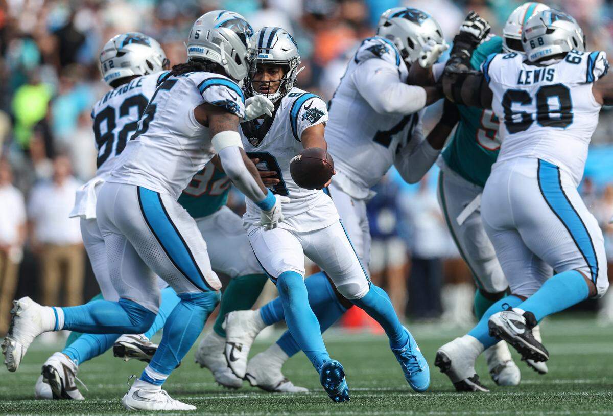 Panthers quarterback Bryce Young, center, hands off the ball to runningback Rico Dowdle during the game against the Dolphins at Bank of America Stadium in Charlotte, NC on Sunday, October 5, 2025.
