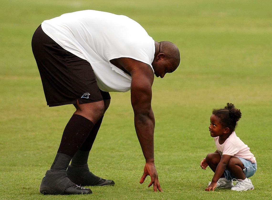In 2003, Panthers defensive end Al Wallace played with his young daughter at Carolina’s training camp following a practice.