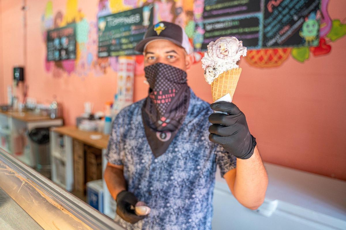 Two Scoops Creamery co-owner Marques Johnson shows off a waffle cone at the Plaza Midwood location on Central Avenue.