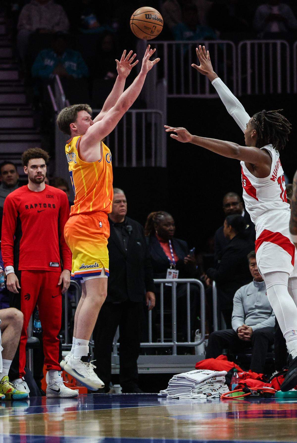 Hornets guard Kon Knueppel, left, shoots for three points as Raptors forward Collin Murray-Boyles tries to block during the game at Spectrum Center in Charlotte, North Carolina, on Saturday, Nov. 29, 2025.
