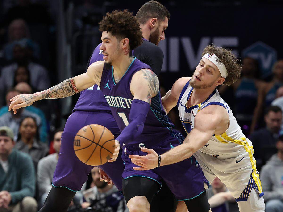 Charlotte Hornets guard LaMelo Ball, left, tries to maintain control of the ball as Golden State Warriors guard Brandin Podziemski, right, tries to make the steal at Spectrum Center in Charlotte, NC on Monday, March 3, 2025.