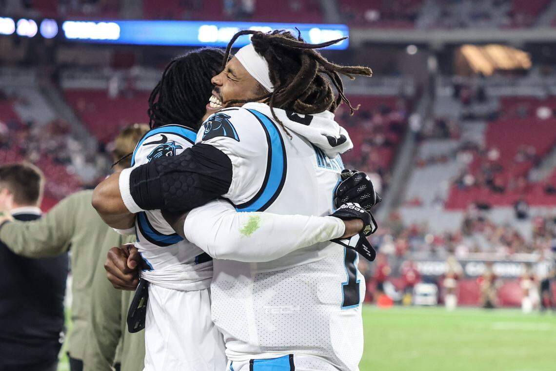 Carolina Panther quarterback Cam Newton and cornerback Donte Jackson hug during the team’s 34-10 win over Arizona Sunday.