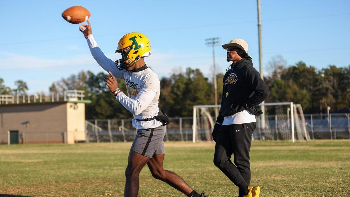 Independence High’s quarterback Justin Little, left, throws a pass as head coach DJ McFadden watches, during practice on Monday, November 14, 2022. Independence is in the third round of the playoffs for the first time since 2013.