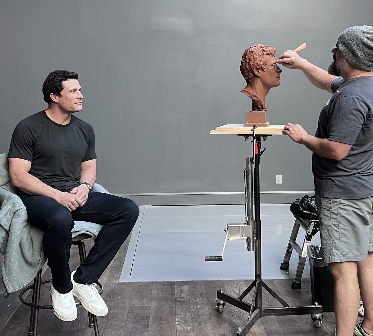 Sculptor Ben Hammond (right) works on the sculpture of former Carolina Panthers star Luke Kuechly in May 2026. A finished and bronzed version of the sculpture will be exhibited at the Pro Football Hall of Fame following Kuechly’s hall of fame induction on Aug. 8 in Canton, Ohio.