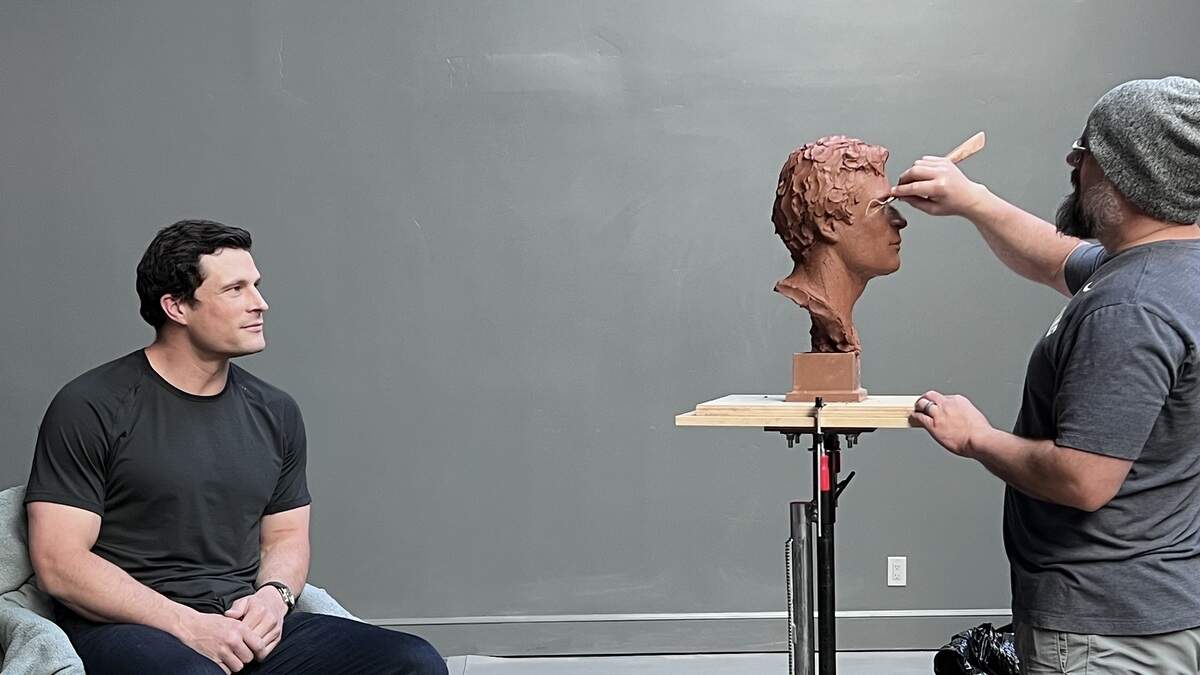 Sculptor Ben Hammond (right) works on the sculpture of former Carolina Panthers star Luke Kuechly in May 2026. A finished and bronzed version of the sculpture will be exhibited at the Pro Football Hall of Fame following Kuechly’s hall of fame induction on Aug. 8, 2026.