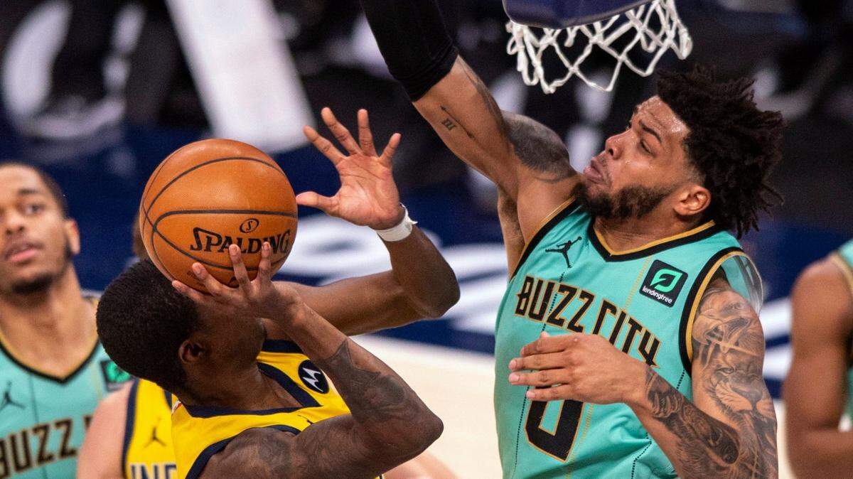 Charlotte Hornets forward Miles Bridges (0) tries to block a shot by Indiana Pacers guard Edmond Sumner (5) during the second half of an NBA basketball game in Indianapolis, Friday, April 2, 2021. (AP Photo/Doug McSchooler)