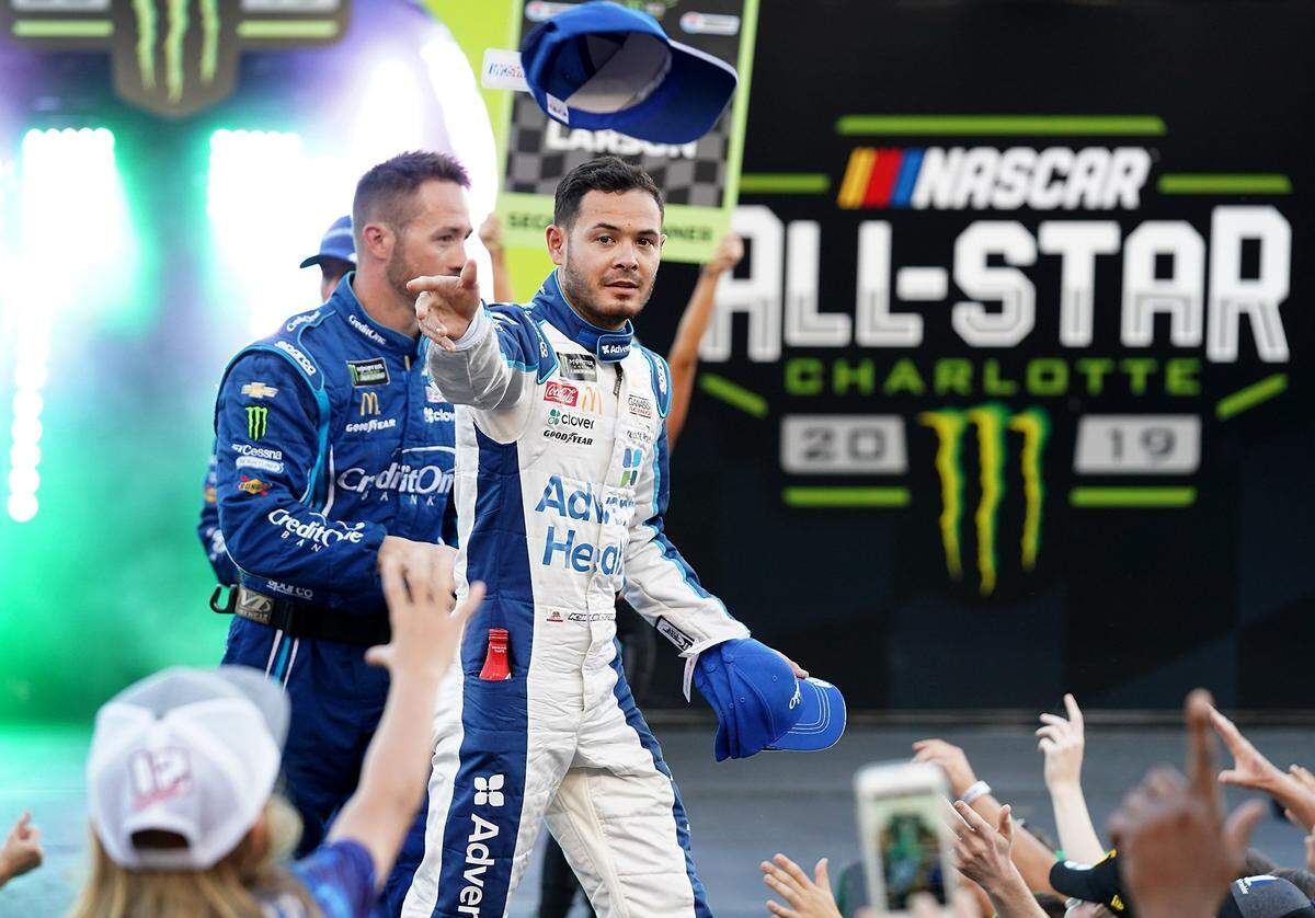 NASCAR driver Kyle Larson tosses caps into the crowd during driver introductions during the 2019 all-star race at Charlotte Motor Speedway. Larson won the race a few hours later.
