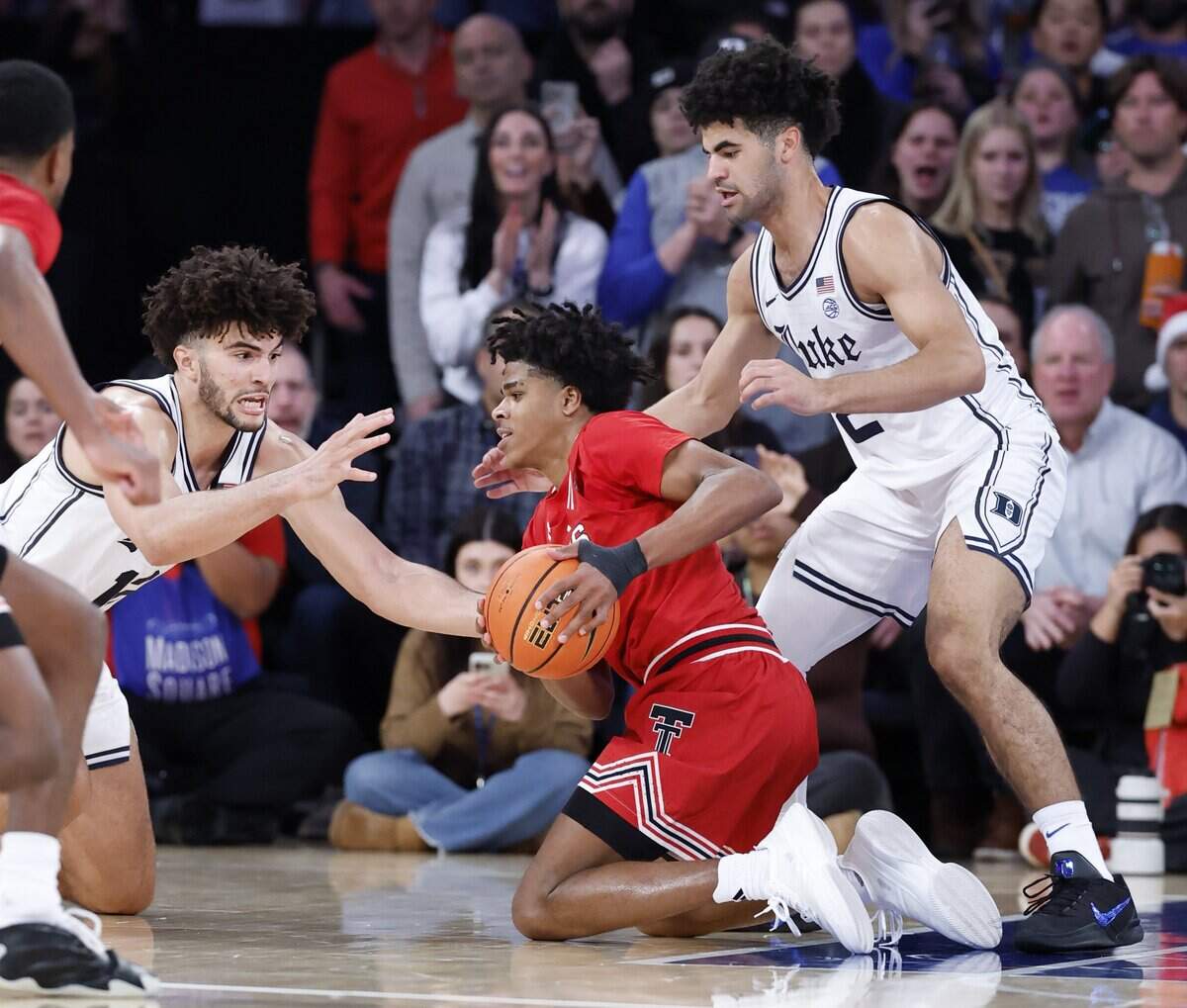 Duke’s Cameron Boozer (12) and his twin brother Cayden Boozer (2) try to take the ball from Texas Tech's Christian Anderson Jr. in December. Anderson scored 23 of his 27 points in the second half in Texas Tech’s 82-81 upset victory.