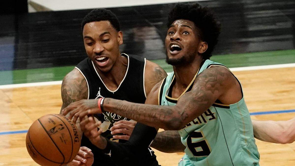 Milwaukee Bucks’ Jeff Teague and Charlotte Hornets’ Jalen McDaniels battle for a loose ball during the first half of an NBA basketball game Friday, April 9, 2021, in Milwaukee. (AP Photo/Morry Gash)