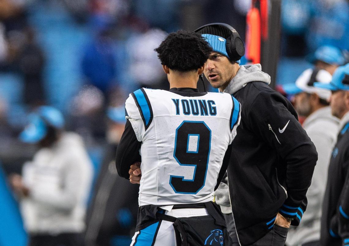 Carolina Panthers coach Dave Canales, right, talks to Carolina Panthers quarterback Bryce Young at the Bank of America Stadium in Charlotte, N.C., on Sunday, December 15, 2024.