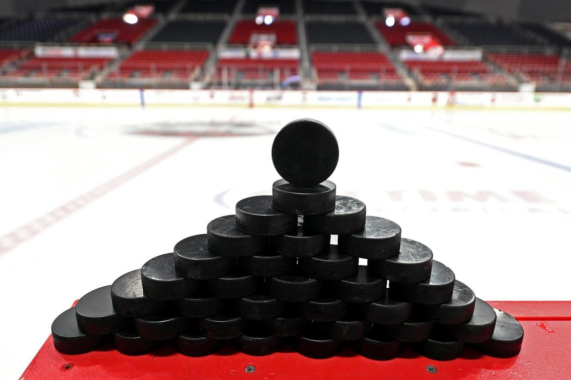 Positioned in a pyramid, hockey pucks wait along the Charlotte Checkers bench at Bojangles Coliseum in Charlotte, NC on Friday, October 18, 2024. The Charlotte Checkers hosted the Cleveland Monsters in the home opener.