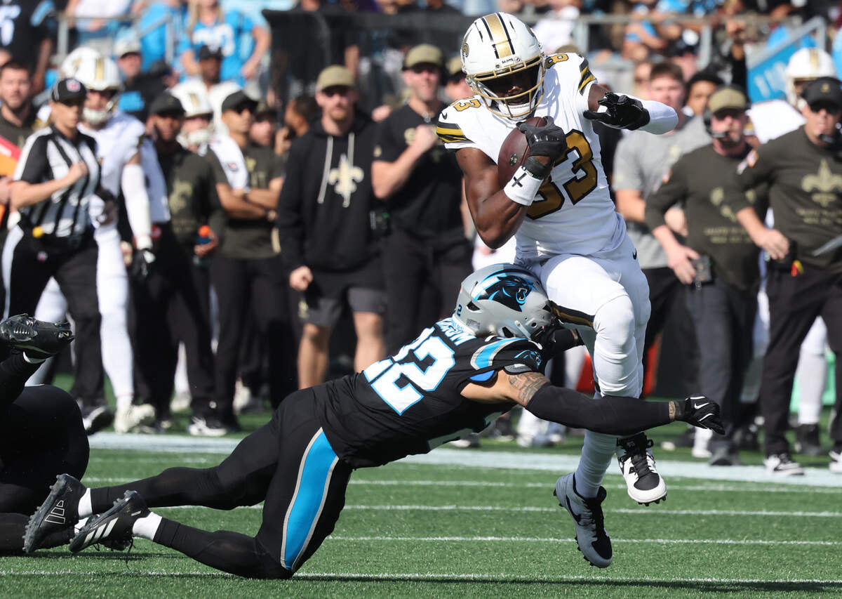 Carolina Panthers’ Lathan Ransom (22) tackles New Orleans Saints’ Juwan Johnson during the fourth quarter on Sunday at Bank of America Stadium.