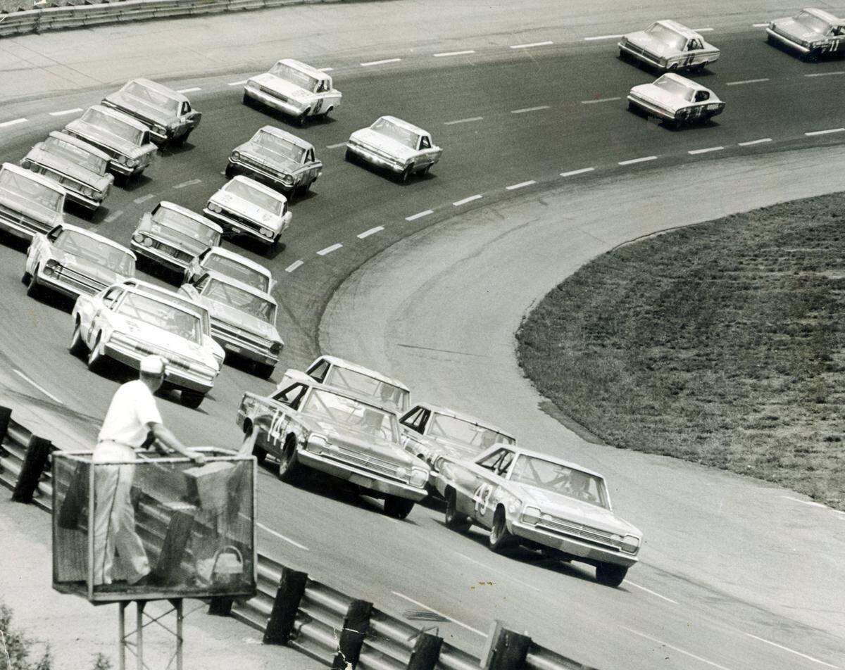 The World 600 race in 1966 as it cranks into high gear shows Richard Petty (43) and Jim Paschal (14), the top two qualifiers leading the pack into the first turn with their 1966 Plymouths. Petty crossed the finish line first, but in another Plymouth — Marvin Panch’s.