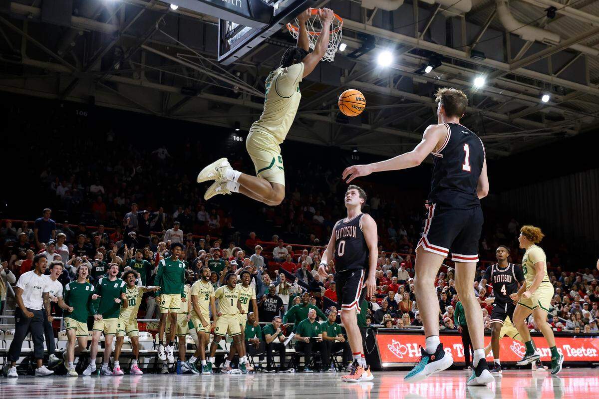 Charlotte 49ers guard Isaiah Folkes (5) slam dunks the ball over Davidson Wildcats guard Foster Loyer (0) and Davidson Wildcats guard Reed Bailey (1) during a game at Belk Arena in Davidson, N.C., Tuesday, Nov. 29, 2022.